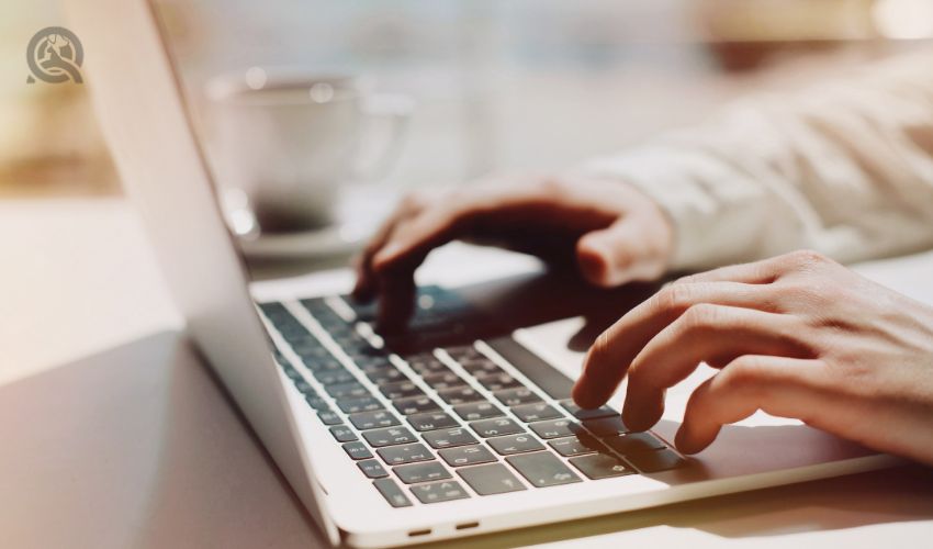 Person's hands typing on laptop